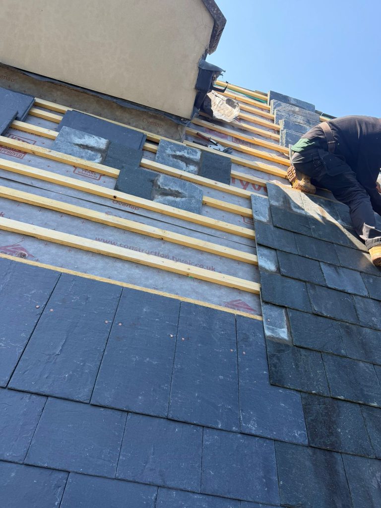 Contractors fitting new slate roof tiles near Shepton Mallet