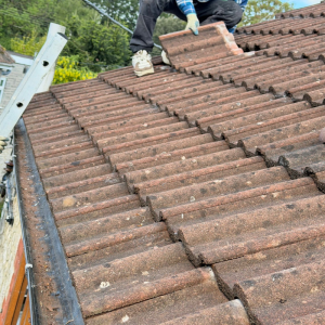 A roofer removing old roof tiles ready for a roof repair