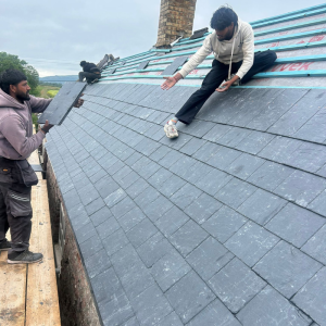 Roofers installing new slate roof tiles on a house in Wedmore Somerset